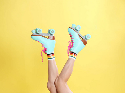 彩色背景特写的复古溜冰鞋的年轻女子