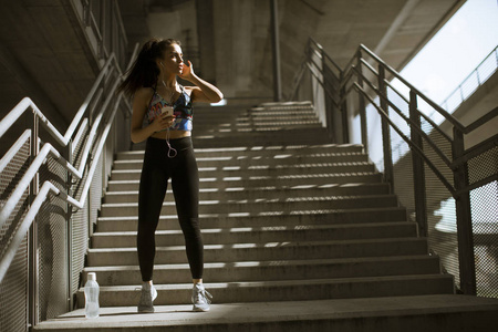 年轻的健身妇女在城市环境中户外运动