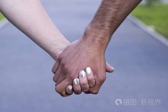 亲密的情侣在爱的手牵着对方的手