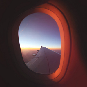 从飞机窗口在美丽的日出视图。豪华旅游平面概念
