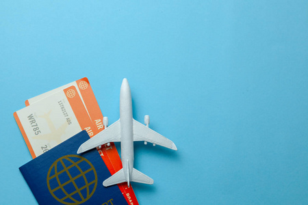 蓝色背景下的飞机和护照和客机型号。复制文本的空间