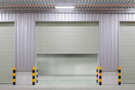 工业背景厂房外的卷帘门或卷帘门和混凝土地板。