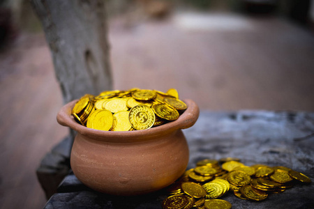 在背景模糊的木桶上堆放金币，用于商业规划投资和节约未来资金