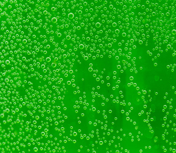 绿色背景下水中的圆形空气滴图片