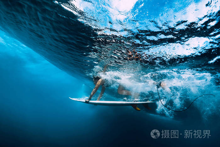 冲浪女孩与冲浪板潜水水下与乐趣下大海浪.