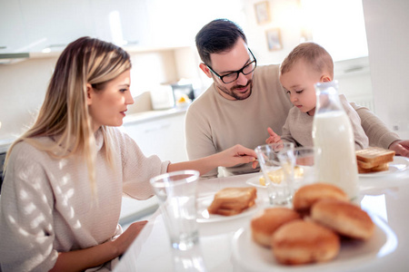 幸福的一家人在家里厨房里一起吃早餐。