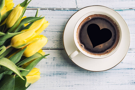 观景杯形成咖啡与心和春天郁金香在木桌上。