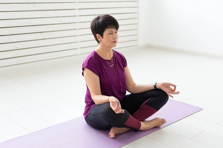 健康的生活方式, 人和运动的概念有吸引力的中年妇女练习瑜伽在莲花姿势