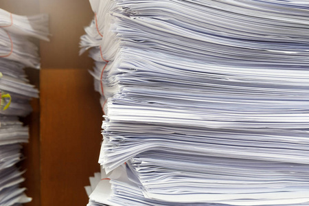 将业务文件堆放在办公桌报告文件堆上