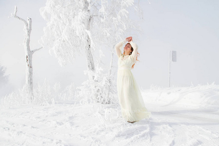 新娘站在海霜桦树附近。冬季肖像画