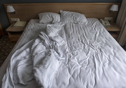 白色床上用品床单和枕头的顶部视图。