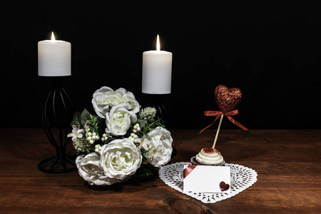 美丽的花束，白色的蜡烛，白色的心形的迪莉，有一个蛋糕和一个摘心在一个木桌上的支架上。 母亲节复活节情人节生日圣诞节