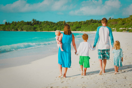 幸福的家庭，与孩子们在热带海滩上行走