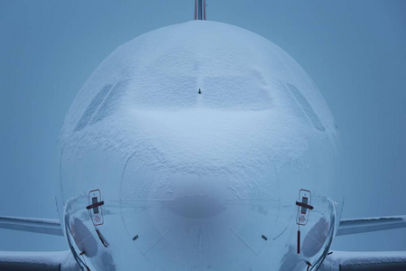 机场的冬天早晨。 飞机被雪覆盖，等待除冰。
