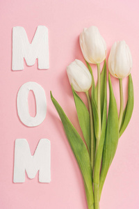 白色郁金香和纸字妈妈粉红色背景