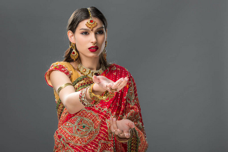 印度女孩用传统的纱丽做手势，并用灰色隔离配饰