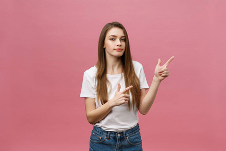 特写镜头严重严格的年轻女子穿白衬衫看起来压力很大, 用手指在粉红色的背景隔离