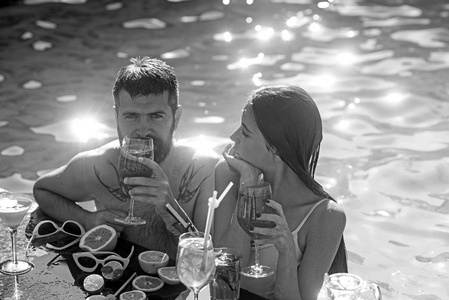 一对长胡子的男人和女人与鸡尾酒和水果在迈阿密。暑假和海上游泳。在马尔代夫的男人和女孩的鸡尾酒。朋友和家人。泳池派对在水疗度假村放