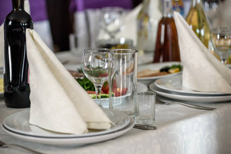 美丽的桌子设置与陶器和鲜花的聚会，婚宴或其他节日活动。餐饮活动晚餐的玻璃器皿和餐具。