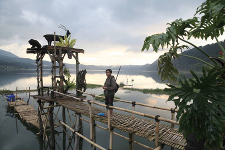 在古火山查图尔巴厘岛火山口的布丹湖和坦布林根湖上钓鱼的竹桥