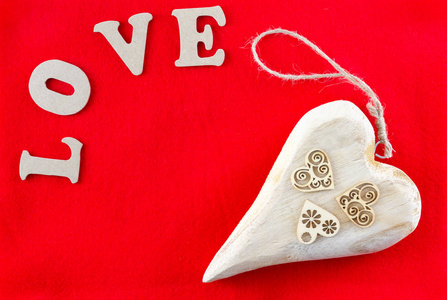 单词爱和心使用木制物体在红色背景设计的情人节