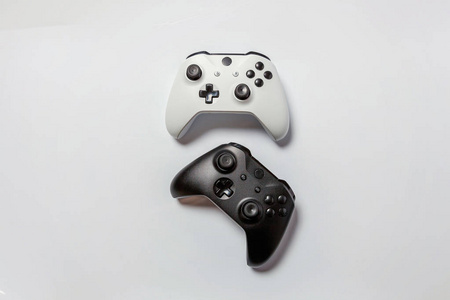 白色和黑色两个操纵杆游戏垫游戏机隔离在白色背景。