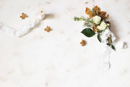 女性的冬季婚礼, 生日还是生活的场景。丝带和一束干枫叶绣球花白玫瑰和果蝇。大理石桌背景。平面布局, 顶部视图