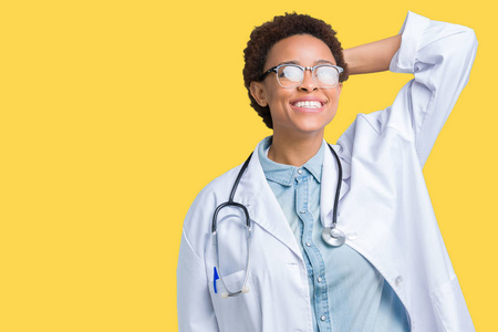 年轻的非洲裔美国医生女士，穿着医用外套，背景偏僻，微笑，自信，抚摸头发，手势，姿势迷人
