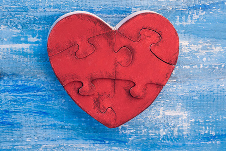 s day concept. Wooden heart puzzle of a red color on a blue wood