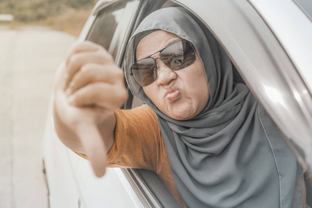 亚洲穆斯林女司机的肖像，因为交通的尖叫和粗鲁的手势而变得愤怒和愤怒