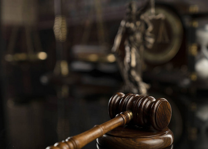 法律概念。 法官雕像的木槌，司法规模和法律书籍。 法庭图书馆。