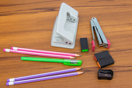 彩色钢笔铅笔和泡泡学校和办公室用品在棕色木桌背景。