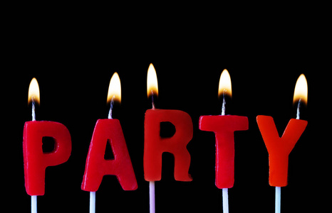 派对用红色生日蜡烛在黑色背景下拼出