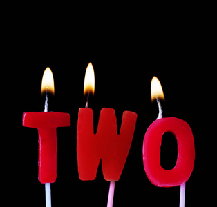 两支红色生日蜡烛在黑色背景下拼出