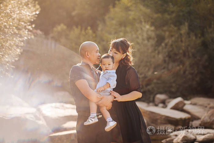 幸福的韩国家庭在河边散步,在山上爸爸妈妈和儿子亚洲人笑着拥抱