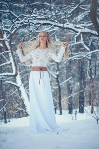 冬天美女。 美丽的时尚模特女孩，在冬天的森林里在冬季森林。 节日化妆和美甲。 有冰雪发型的冬季女王。