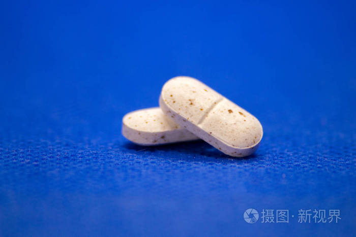 蓝色背景上有许多白色药片. 白色药丸概念药房. 毒品.