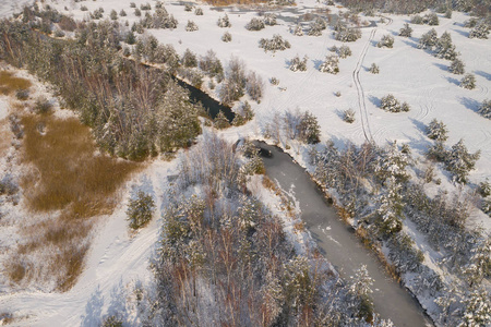 鸟瞰冬季积雪覆盖森林和冰冻湖从上面捕捉到的无人机。