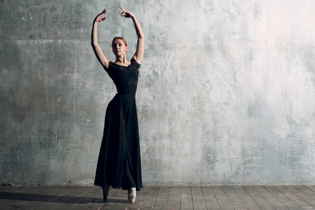 芭蕾舞女演员。年轻美丽的女子芭蕾舞演员，穿着专业服装，尖鞋和黑色连衣裙。