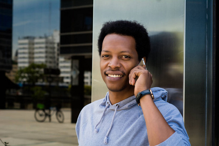 年轻黑人在外面的手机上说话的肖像。