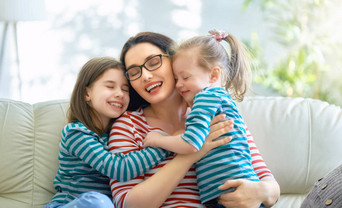 s day Mom and her daughters children girls are playing, smiling