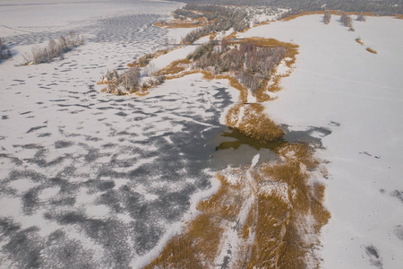 鸟瞰冬季积雪覆盖森林和冰冻湖从上面捕捉到一架无人机。