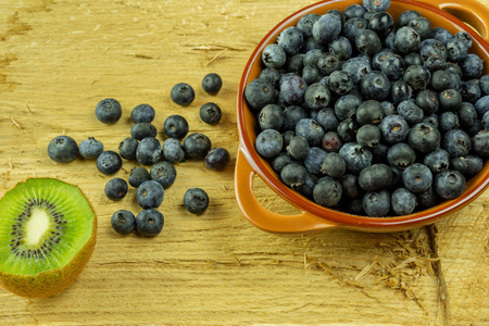 蓝莓在乡村木板上。 蓝莓在棕色碗，蓝色浆果细节