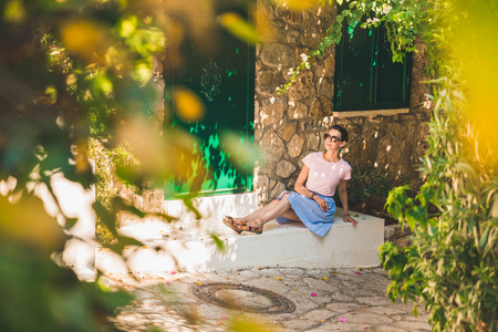 在老马尔玛里斯美丽的街道上的旅游女孩。在土耳其的老镇度假村, 狭窄的街道, 房屋之间有来自古老石头绿色植物和鲜花的楼梯