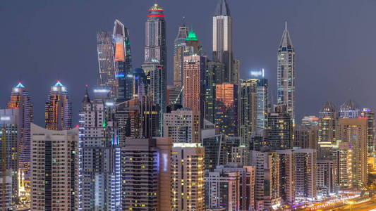 迪拜码头塔全景白天到晚上过渡时间灯打开。 阿联酋摩天大楼的夜间照明。 来自JLT的鸟瞰图