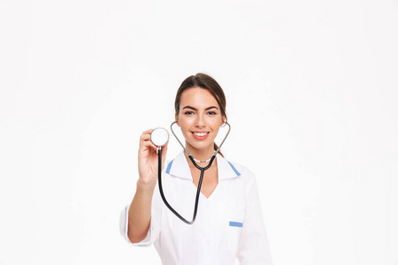 美丽的年轻女子医生穿着制服，用听诊器隔离在白色背景上