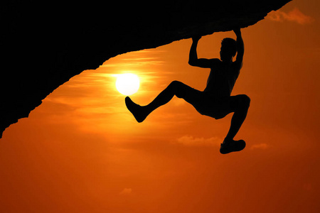 自由爬山在红天日落背景下亚洲男子攀岩剪影