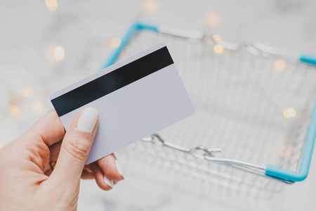 s hand holding payment card and empty shopping basket, concept o