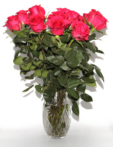 红玫瑰站在水晶花瓶里。 一大束花站在一个巨大的花瓶里。