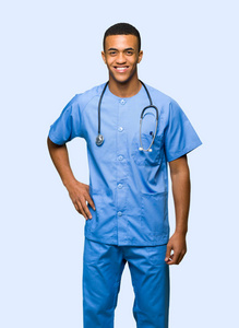 外科医生，一名男子，双臂摆在臀部，在孤立的背景上微笑